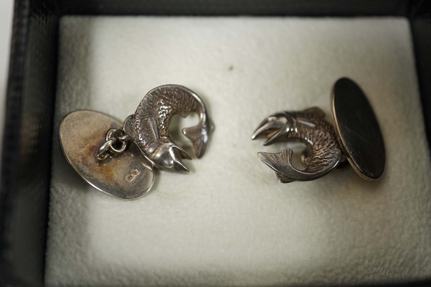 A modern pair of Georg Jensen 925S cufflinks, of swirling form, design no. 443, with original Georg Jensen box, 20mm, together with a modern pair of silver fish cufflinks by Sarah Jones, London, 1993/94. Condition fair a